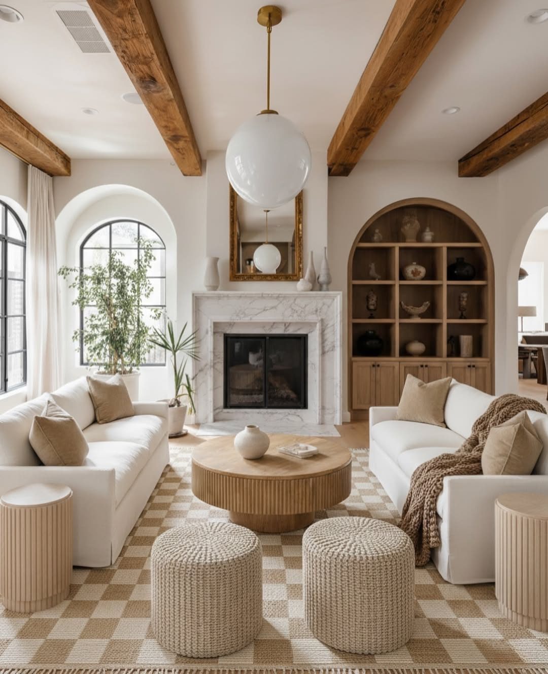 Living room with dark wooden exposed beams on a white ceiling and white sofas.