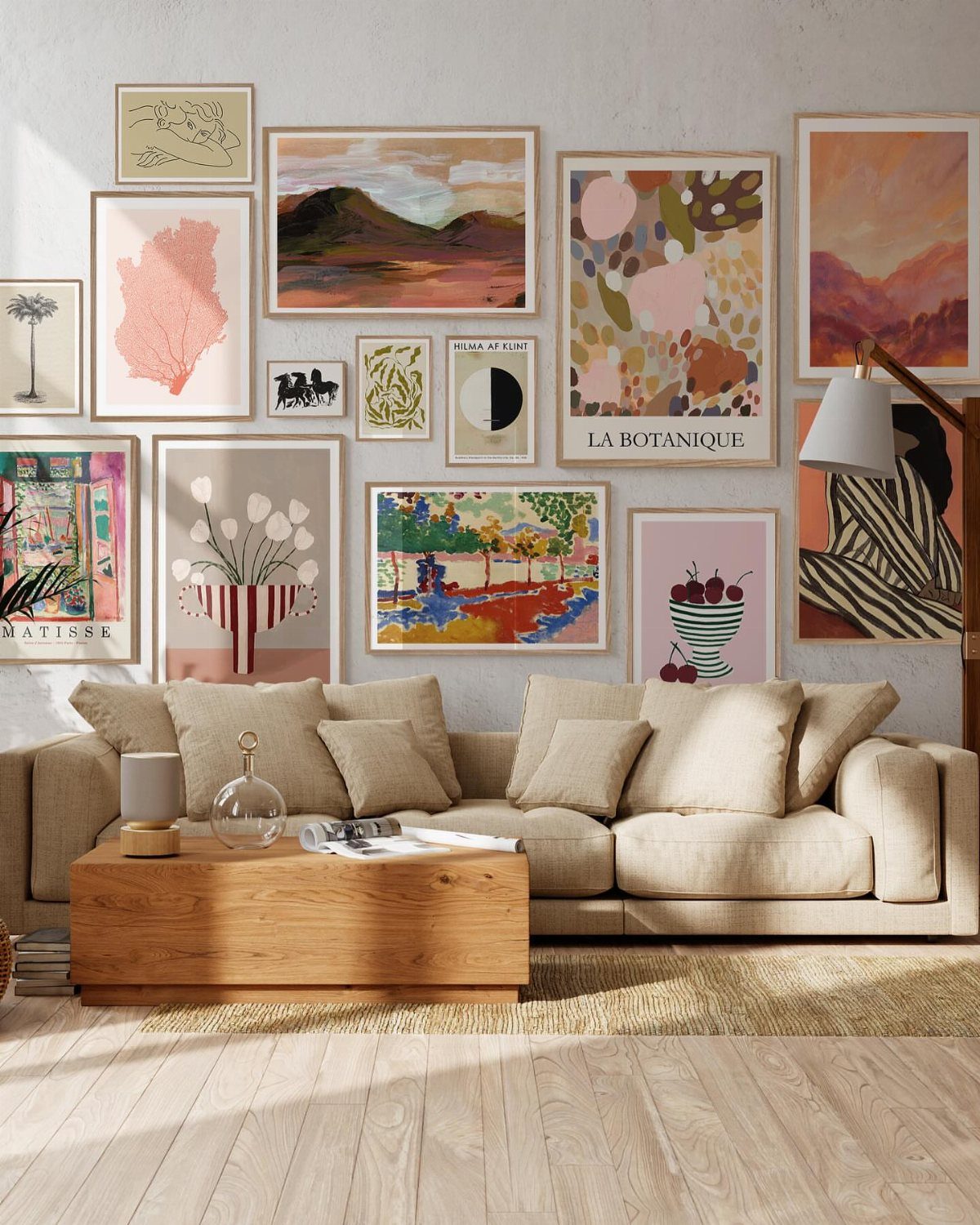 Gallery wall with various framed art prints above a beige sofa and wooden table.