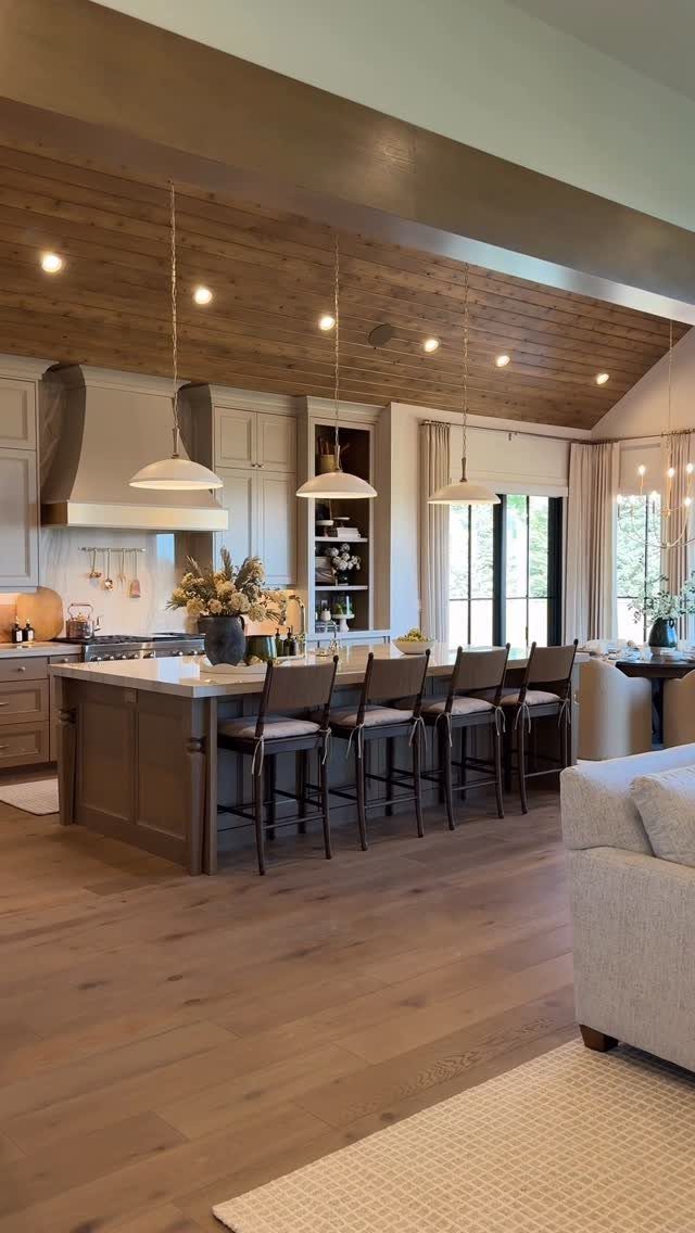 Open concept kitchen and living area with wooden ceiling and large island stools