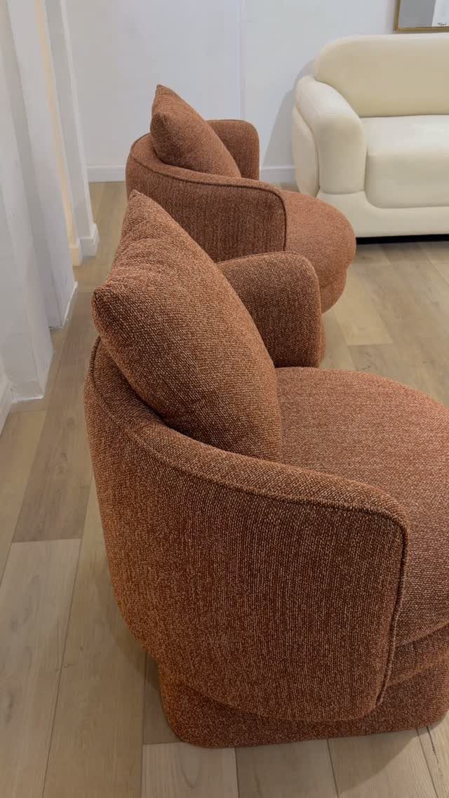 Terracotta orange plush armchairs and a cream sofa on light wooden flooring.