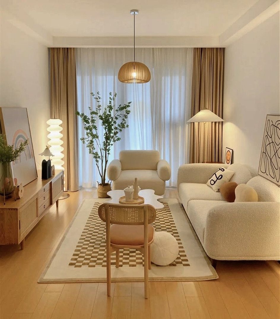 Modern living room with streamlined cream furniture, light wood floors, and organic decor.