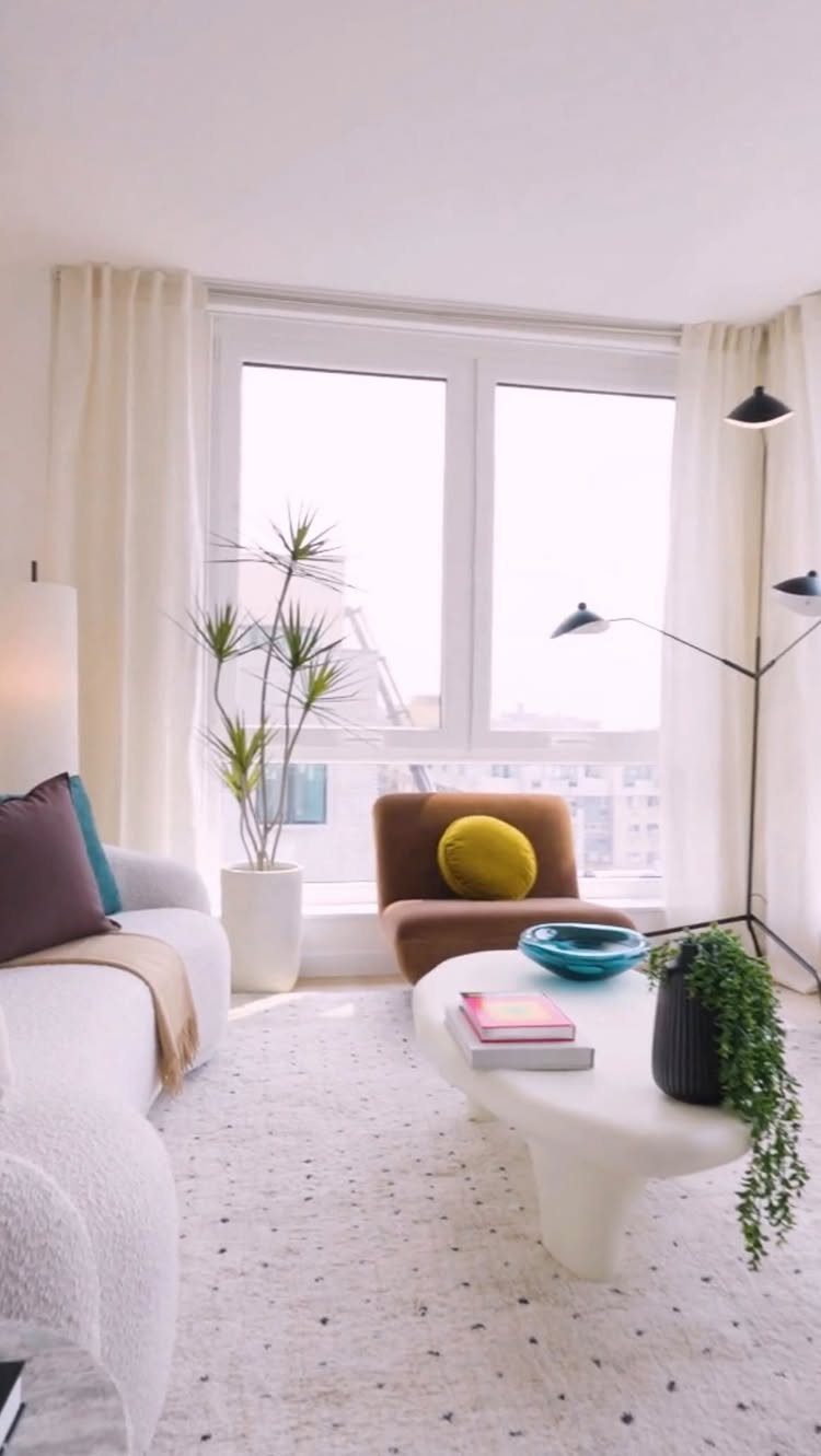 Bright living room with organic shaped white coffee table and brown armchair.