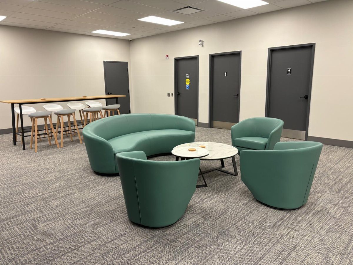 Modern office lounge with teal curved seating, marble table, and high-top wooden table.