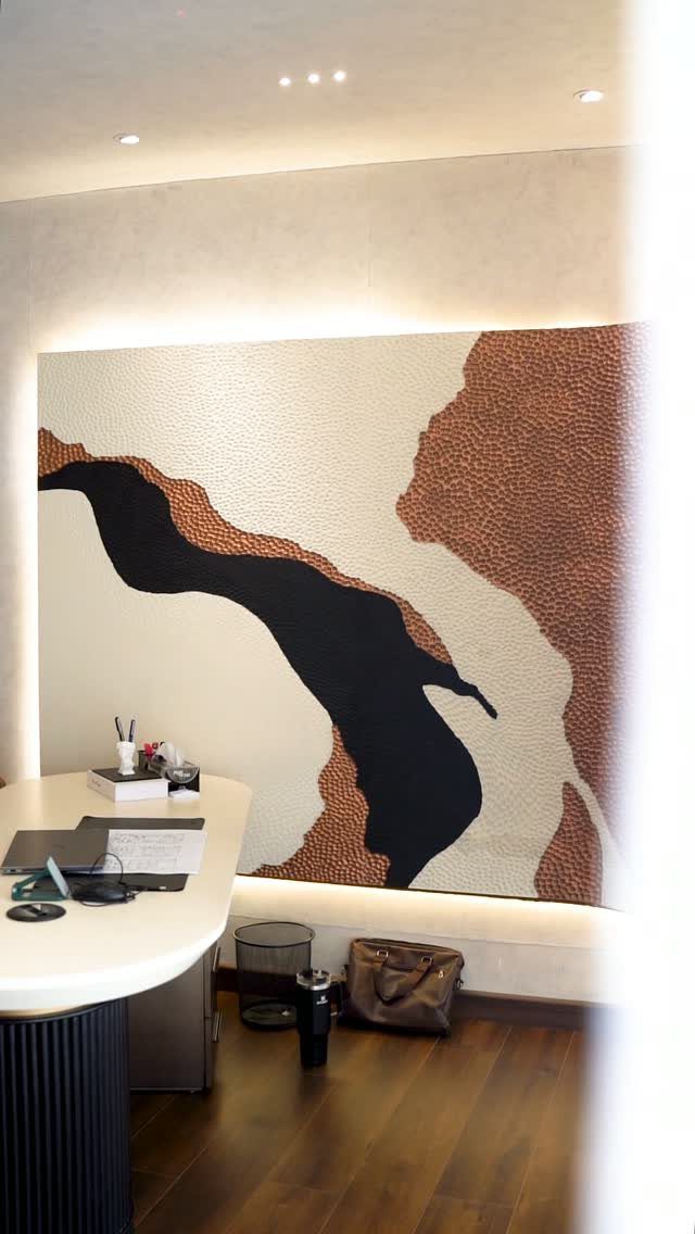 Large abstract wall art with organic shapes hanging in a modern office space