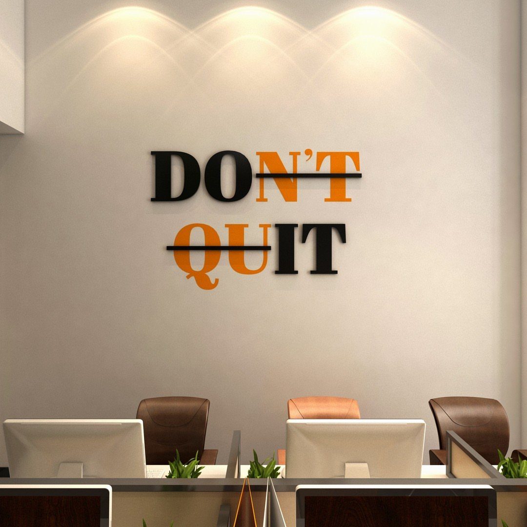 Large 3D motivational quote saying DON'T QUIT on a white office wall