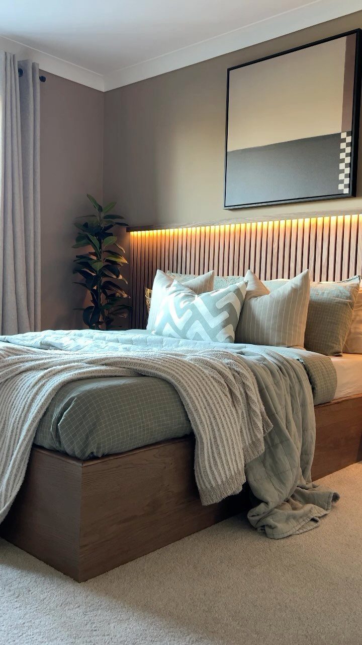 Wooden slatted headboard with warm backlight in a modern taupe bedroom