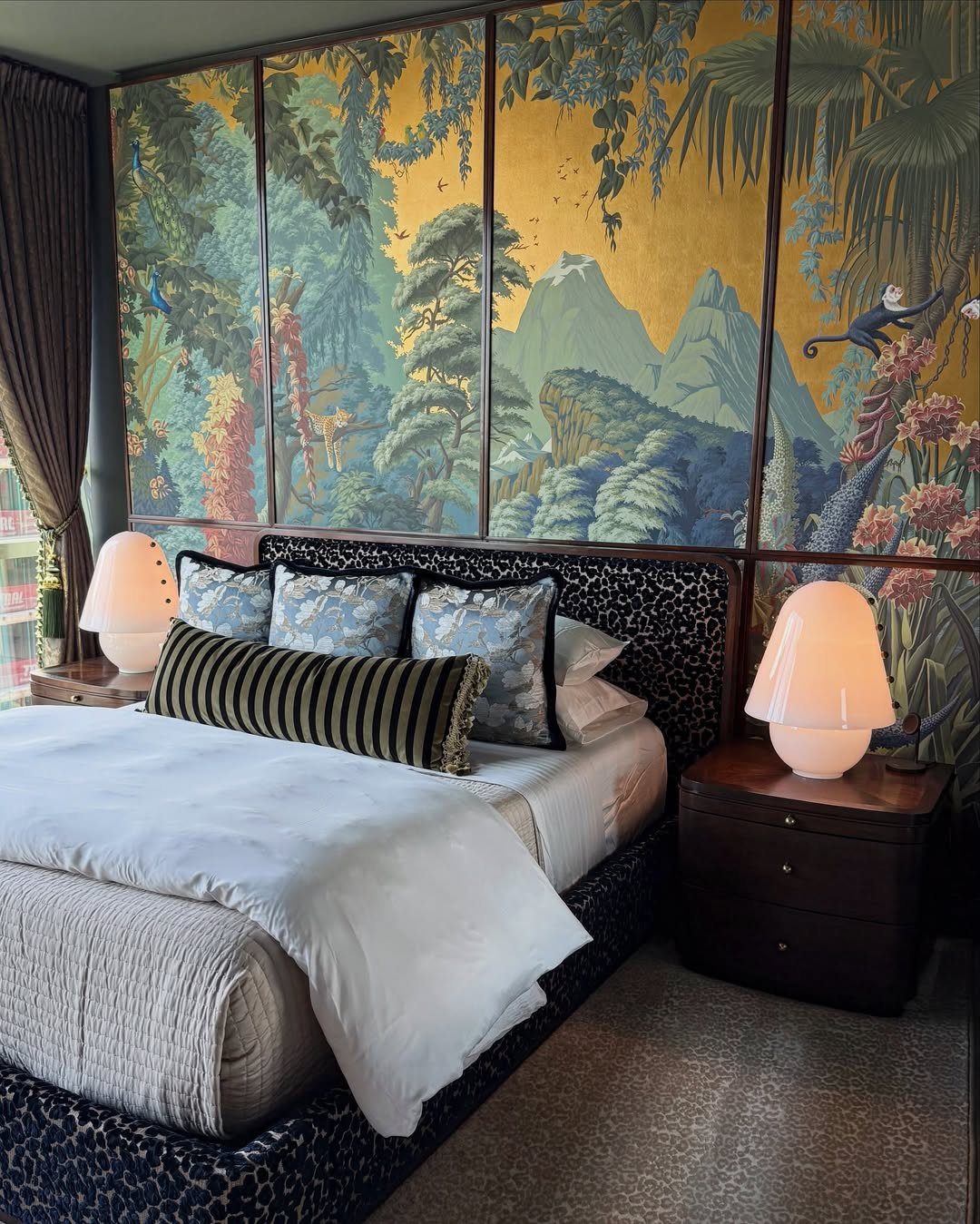 Bed with leopard print frame against a gold landscape mural wall