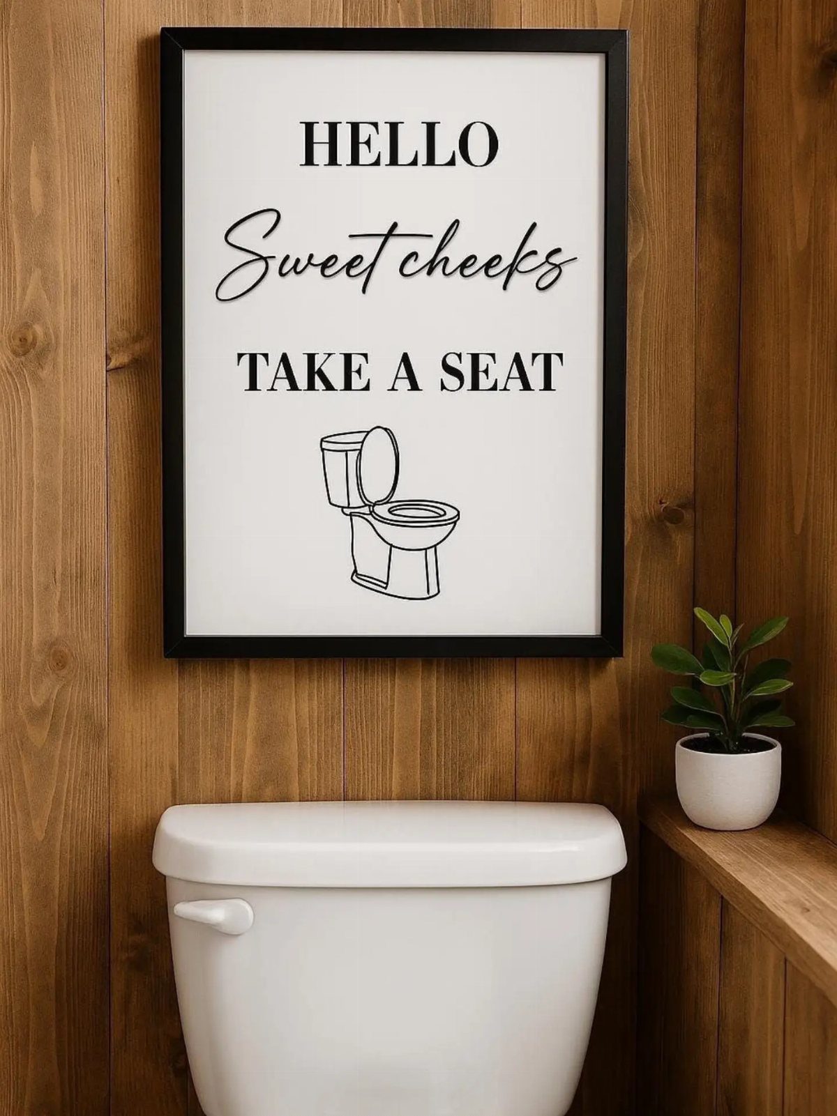Framed humorous bathroom art hanging on a wood wall above a white toilet.