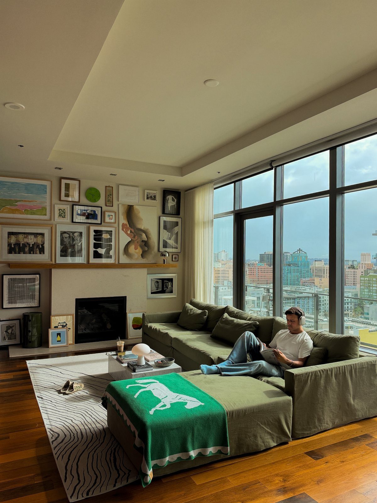 Gallery wall with mixed frames above a fireplace in a modern living room.