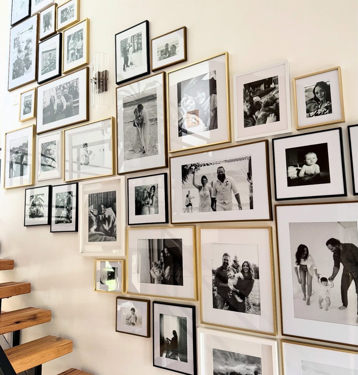 Black-and-white photographs in mixed frames arranged in a gallery wall layout.
