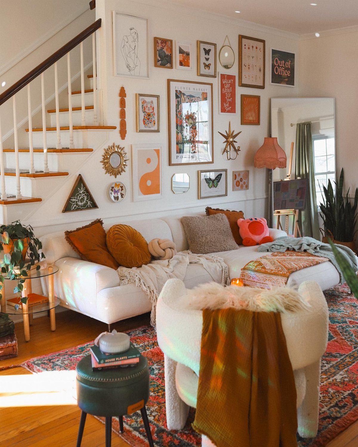 Gallery wall with framed art and unique decorative objects above a white sofa.