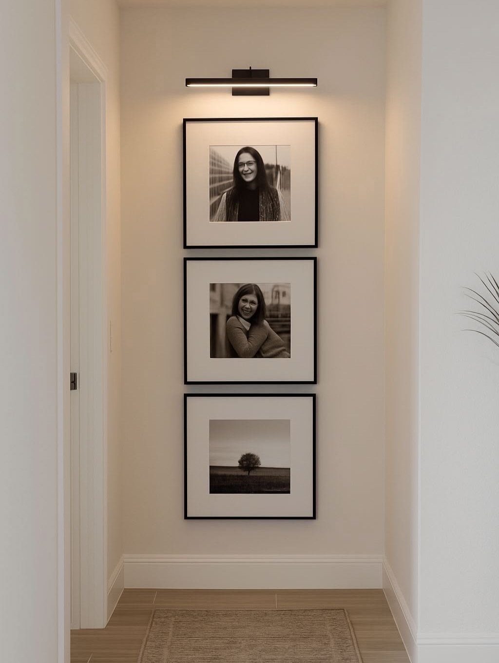 Three black-framed black and white photos hung vertically on a white hallway wall.