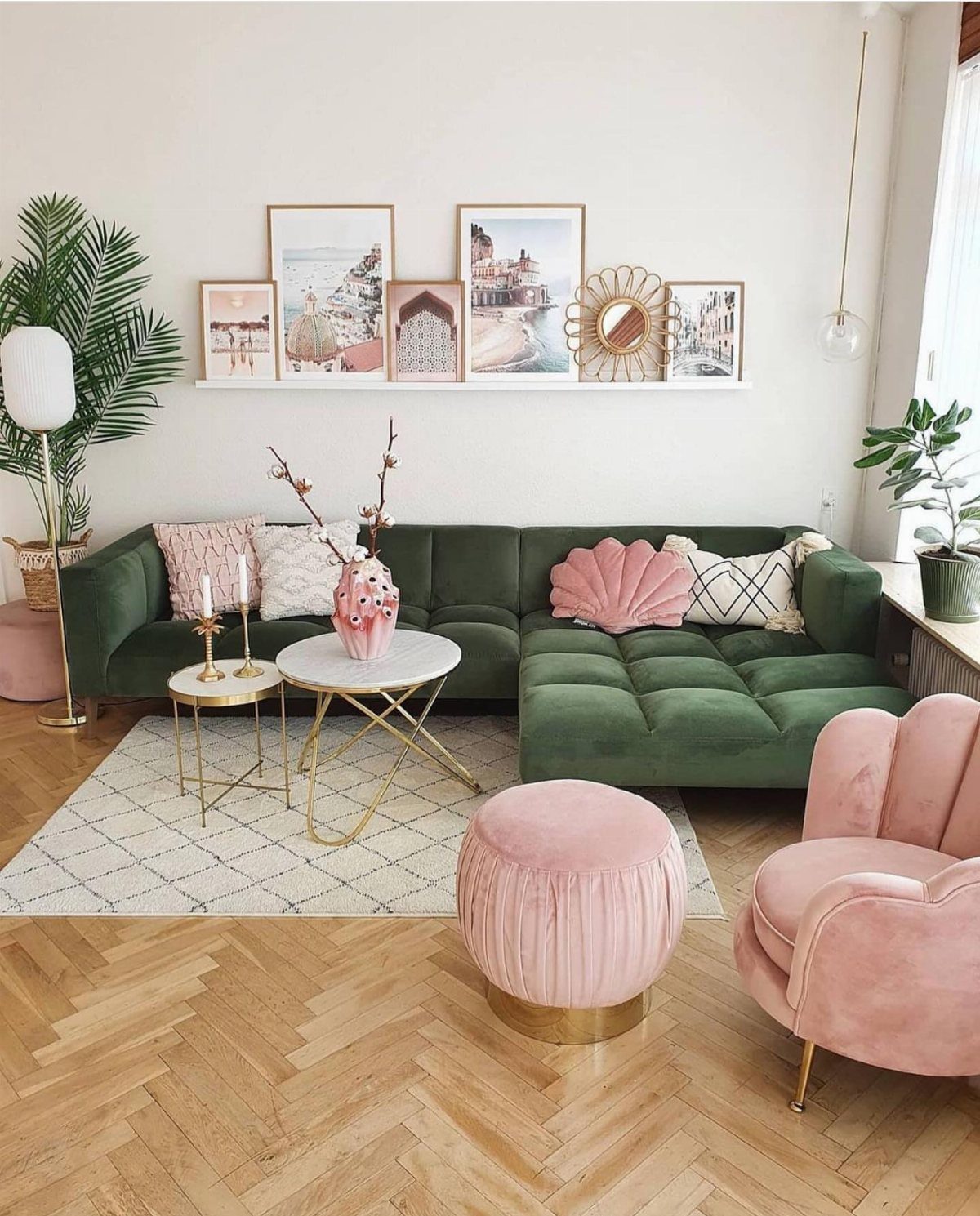 Green velvet sectional and pink velvet furniture in a bright living room with wood floors.