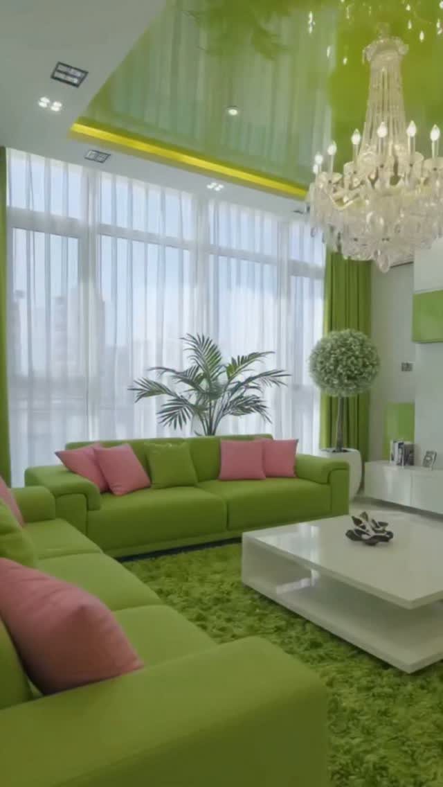 Lime green living room with pink accent pillows, green rug, and crystal chandelier.