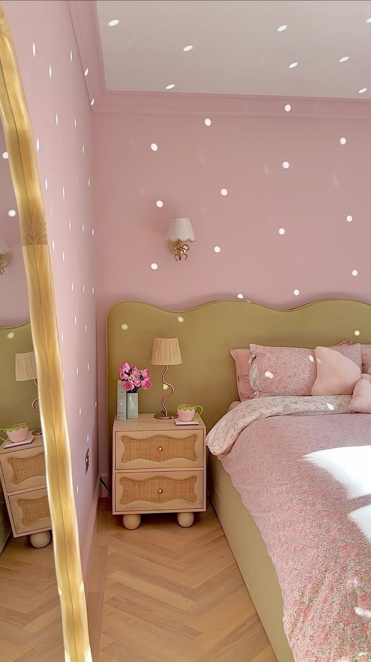 Pink bedroom with a light green scalloped headboard and pink bedding.