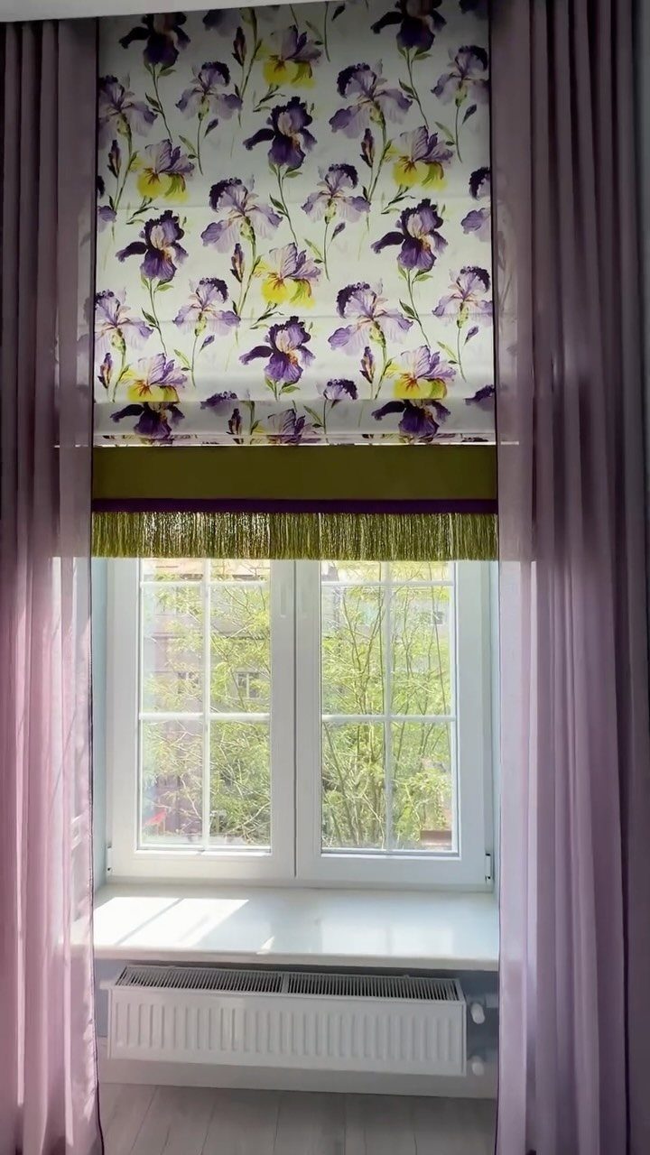 Floral roman shade with purple irises and matching purple curtains framing a window.