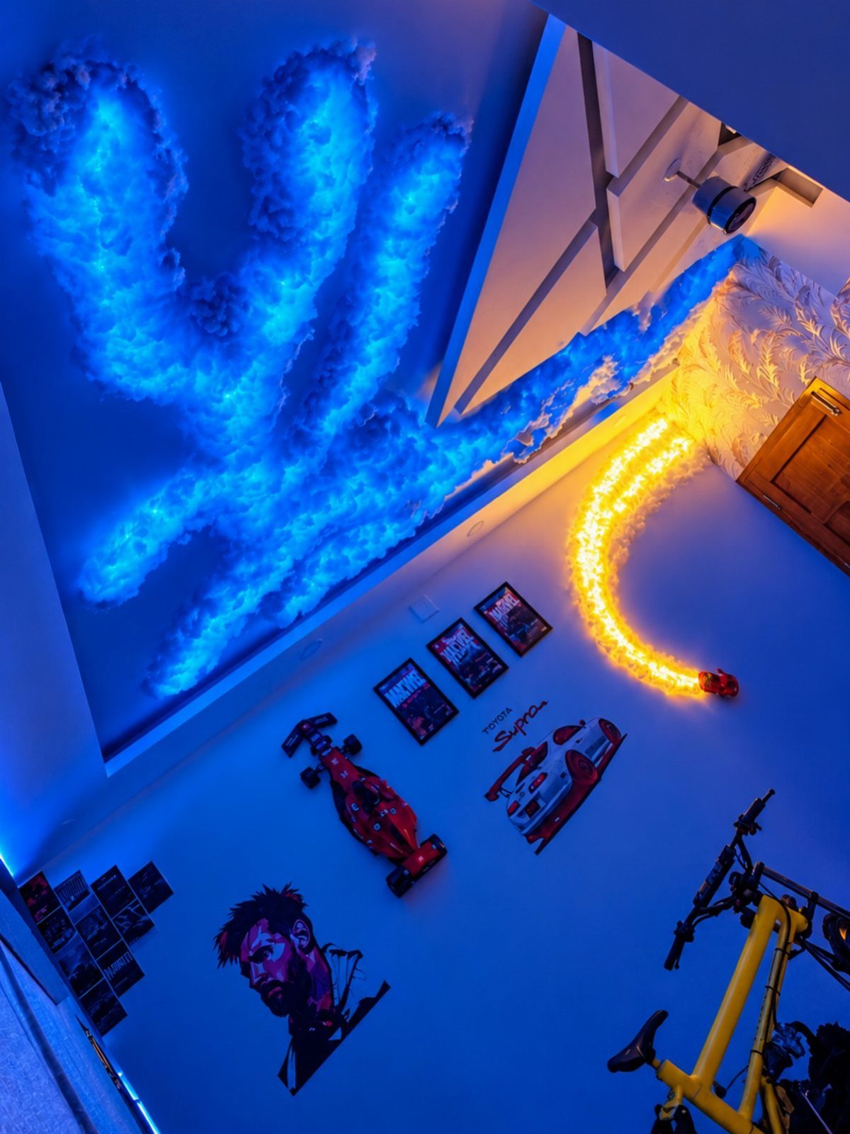 Glowing blue and yellow LED cloud lights installed on a room's ceiling and walls.