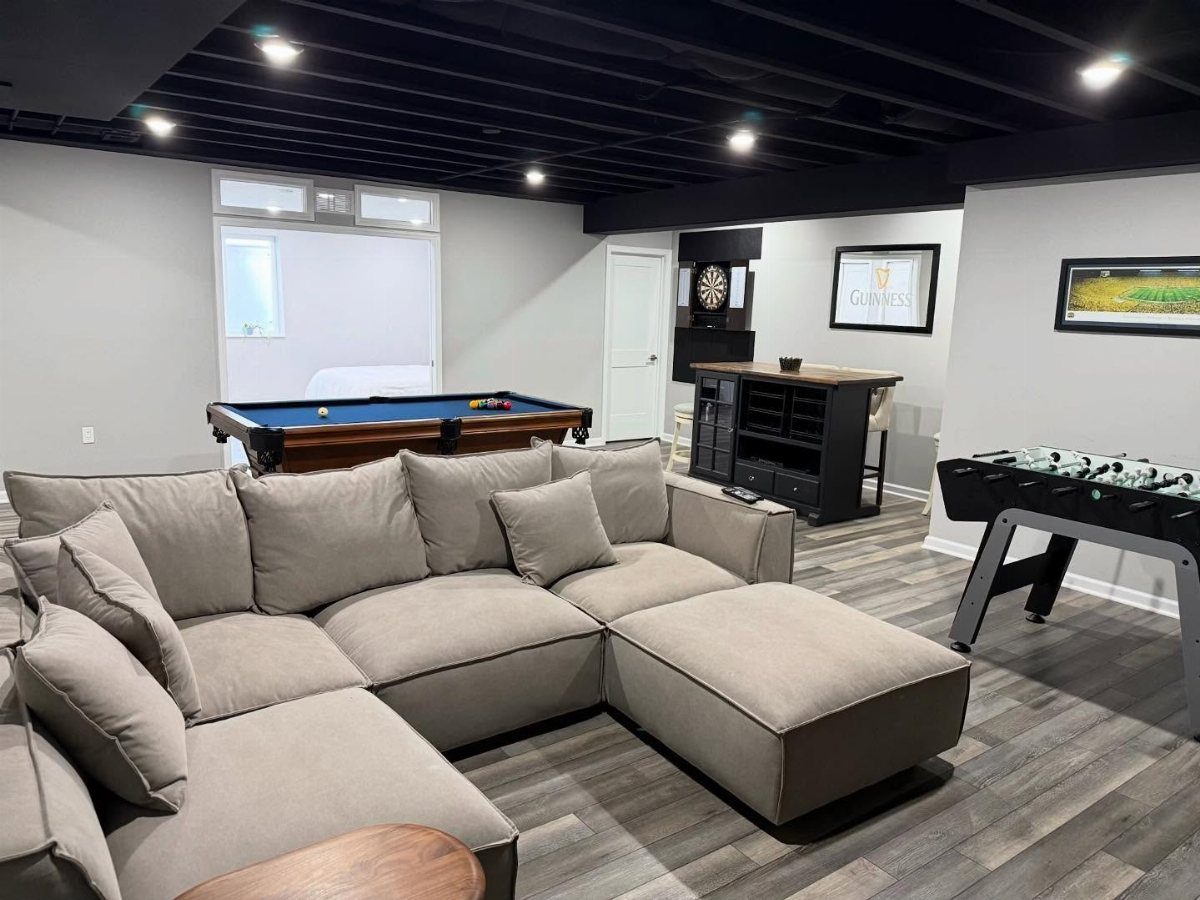 Game room with black ceiling, light gray walls, and a large gray sectional sofa.