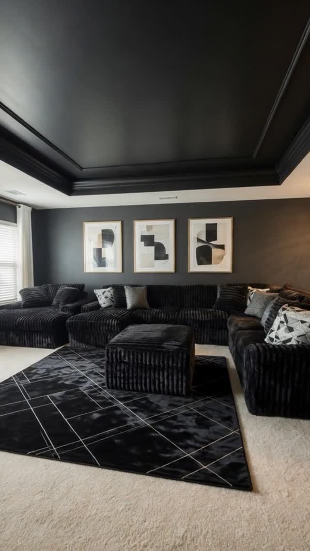 Modern living room with a matte black tray ceiling and dark grey walls.