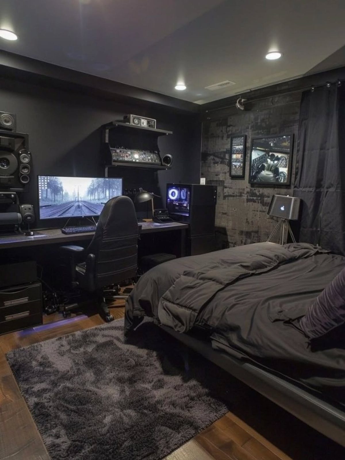 Dark bedroom with black ceiling, black walls, gaming setup, and a black bed.