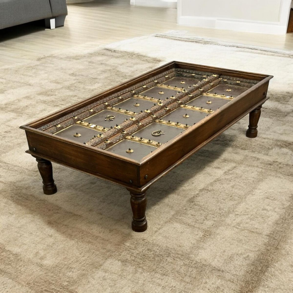 Antique door slab coffee table with carved panels and dark wood finish.