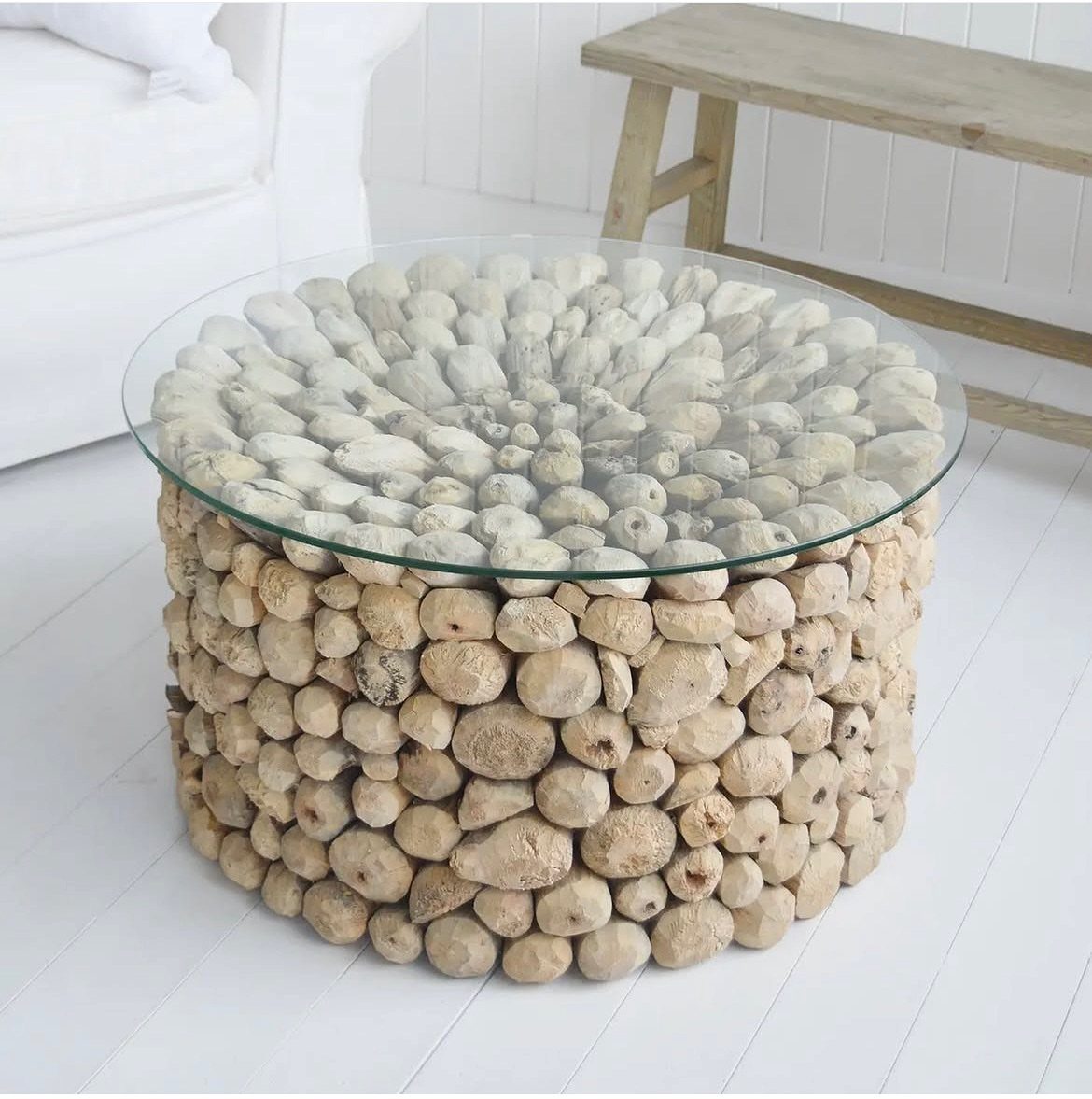 Round coffee table with a glass top and a base made of driftwood.