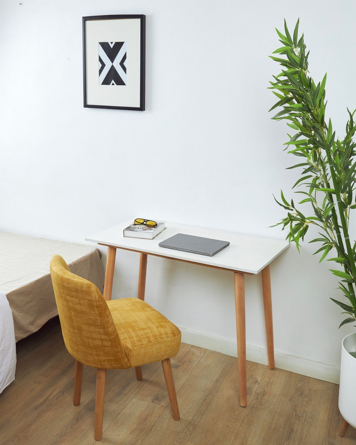 Small white desk with a yellow chair and a green plant in a room