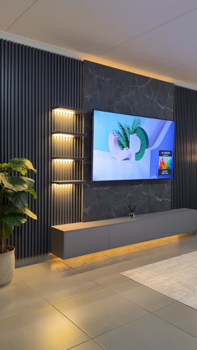 Floating grey TV unit below a wall-mounted television on a marble feature wall.