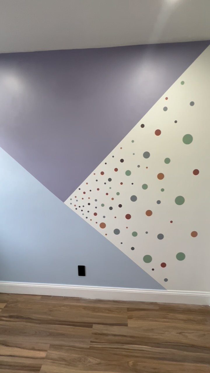 Two toned wall paint with purple and blue sections separated by colorful dots.