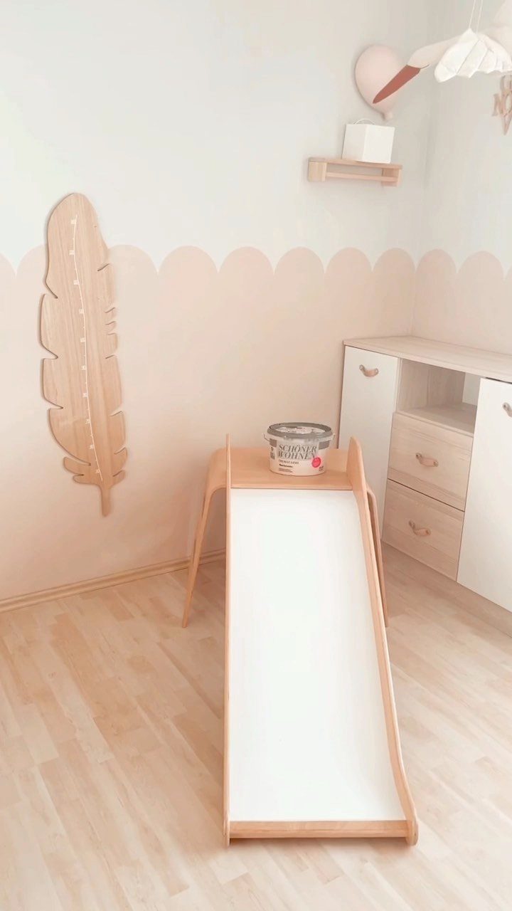 Two toned wall paint with a scalloped peach border in a child's room.