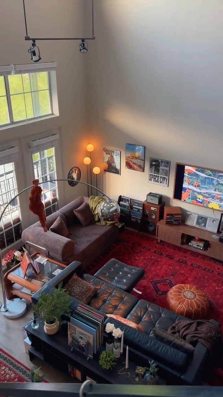 Living room with mid-century modern furniture, leather sofas, and a red patterned rug.