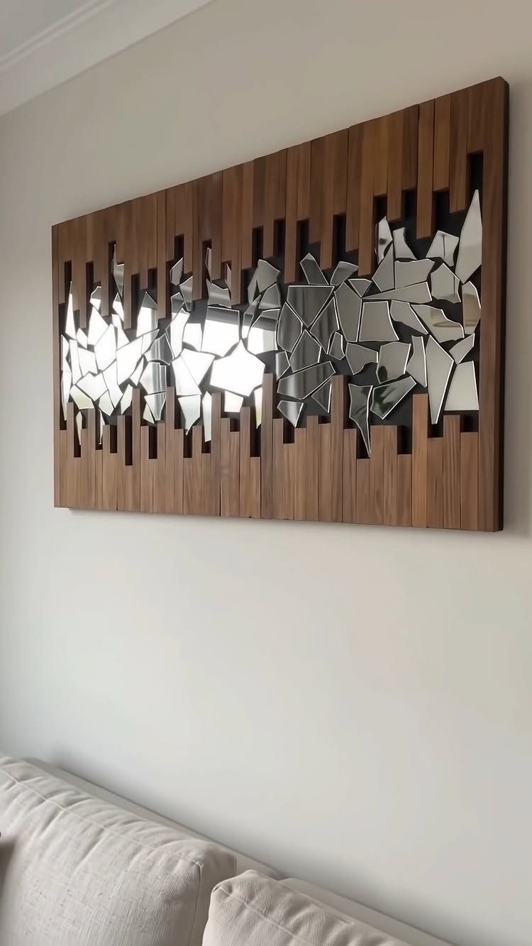 Wooden wall art with mirrored fragments hanging above a light colored couch
