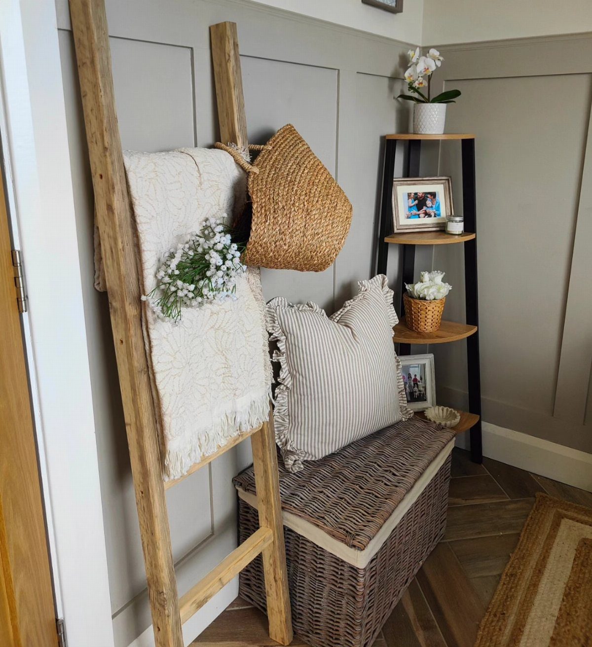 Wooden blanket ladder with white throw and basket against a grey wall